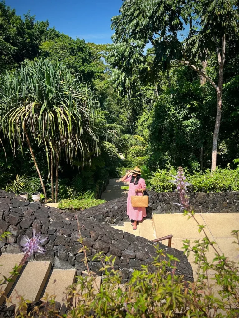 Sustainability at The Datai Langkawi: Saving water by not washing linens daily sigh on bed with yellow Datai cusion in the background