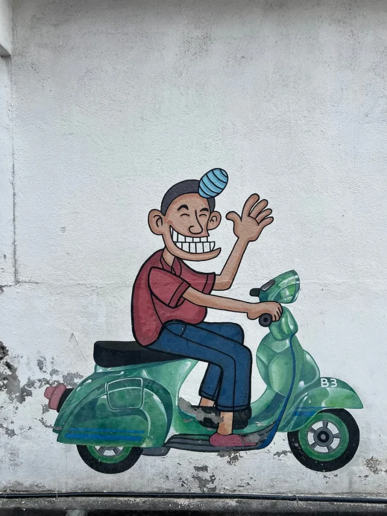 Things to do in Langkawi: Boy on a green bike street art in Kuah Town, Langkawi
