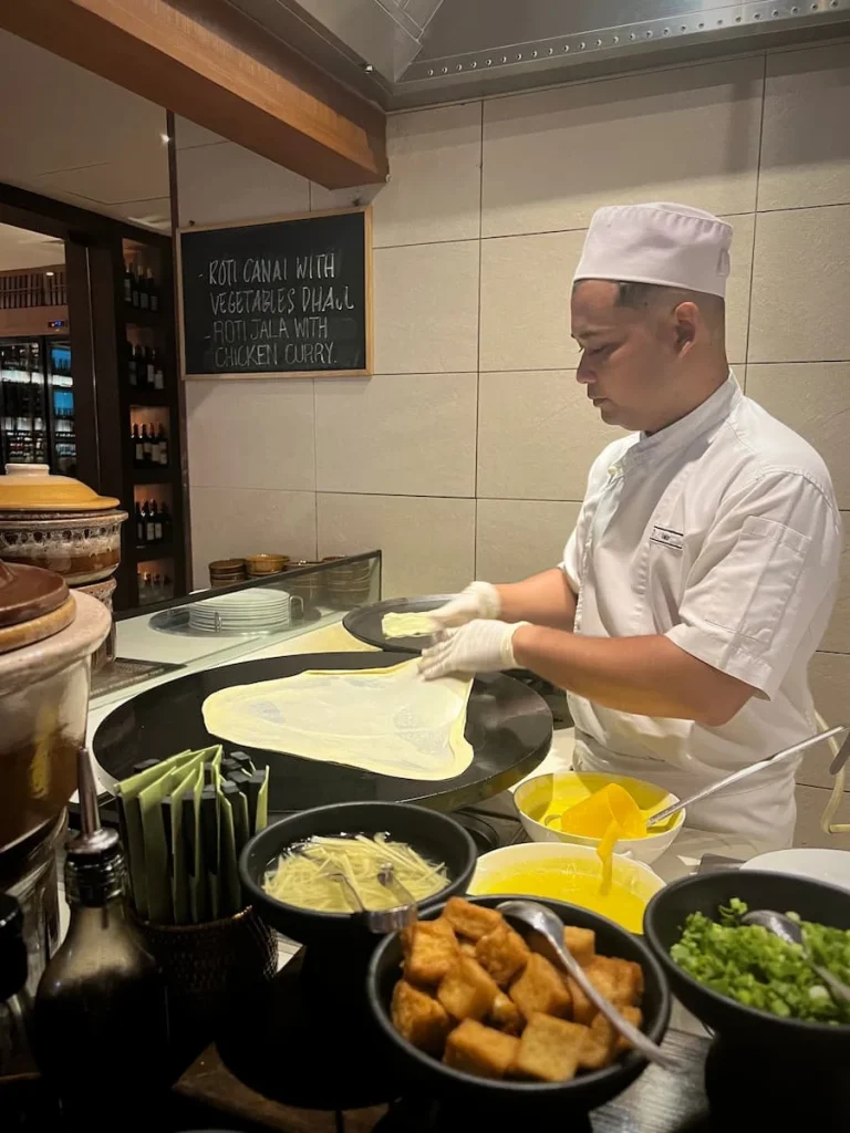 Vegan and Vegetarian food in Langkawi: Chef stretching the Roti dough in a griddle at The Datai Langkawi