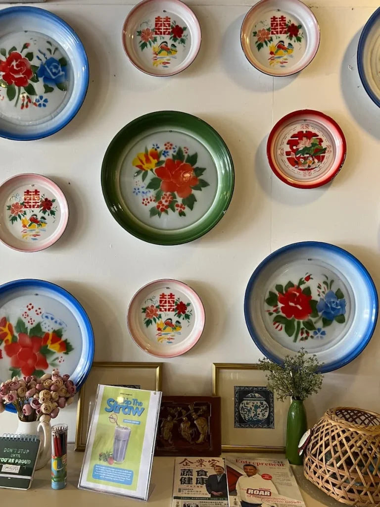 Vegan and vegetarian food in Langkawi: Colourful floral plates on the wall at Melior Cafe