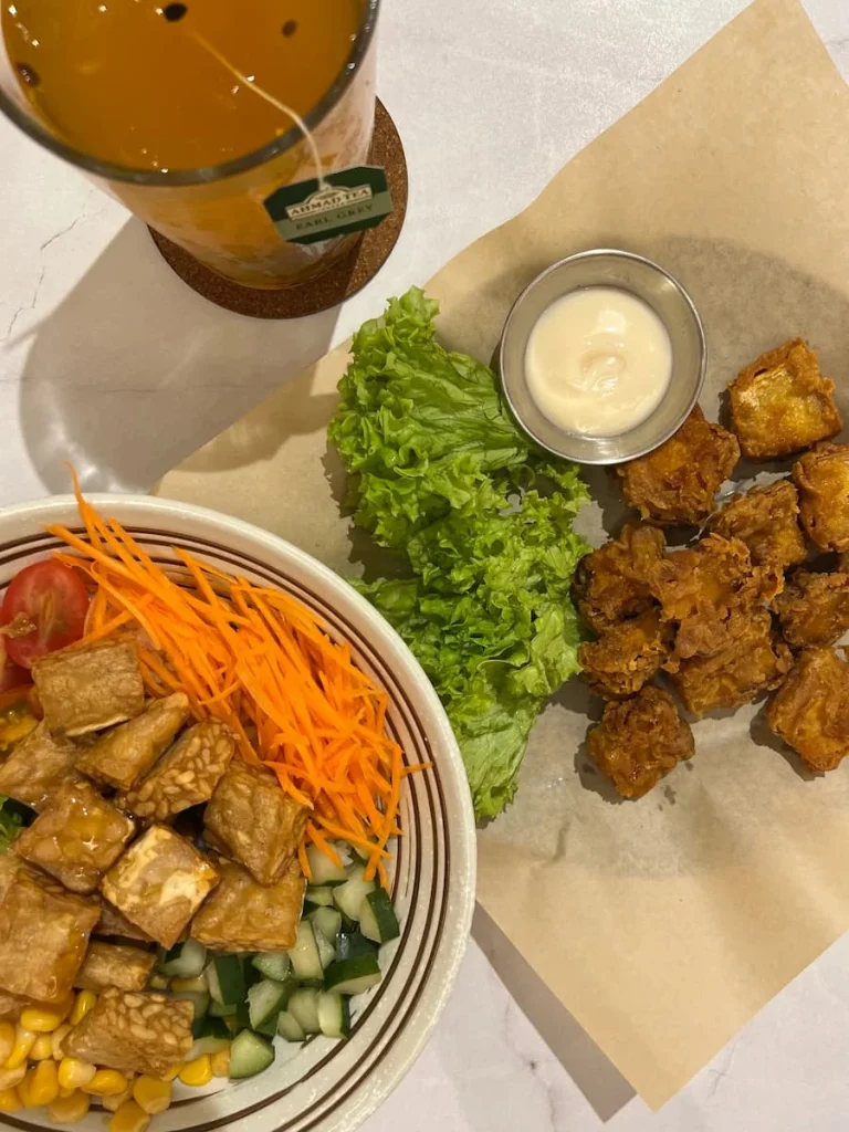 Vegan and Vegetarian food in Langkawi: Flatlay of Tempeh rice bowl and fried musroom Karage at Nian cafe with Earl Grey and passionfruit iced tea.