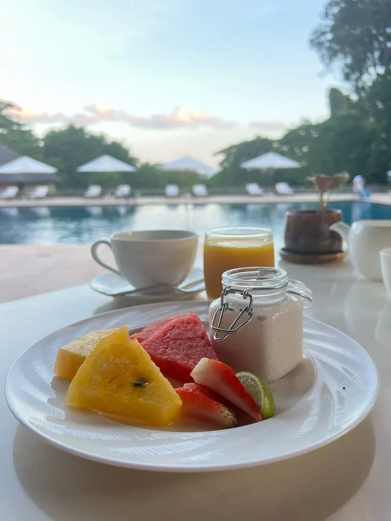 Fruit, yoghurt and coffee at breakfast infront of the main pool at The Datai