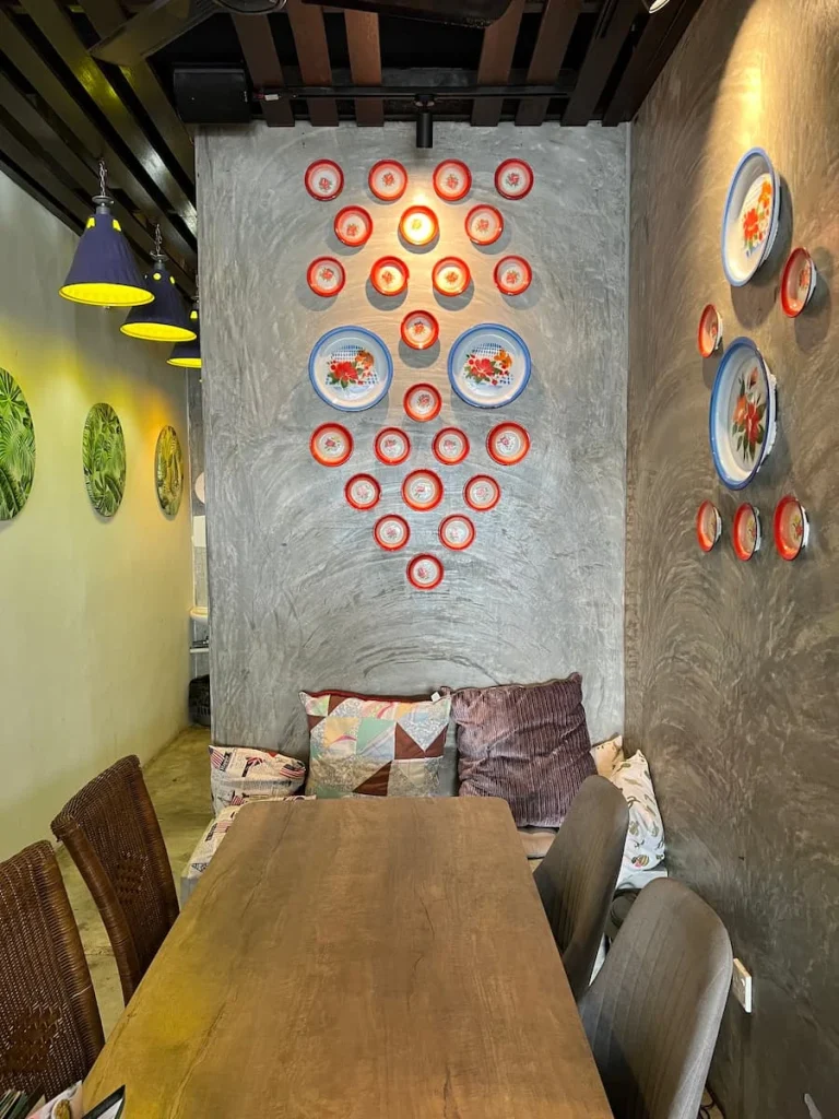Vegan and vegetarian food in Langkawi: Large table with colourful plates on the wall at Melior cafe
