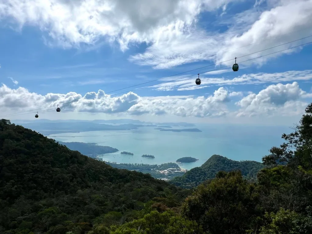 Things to do in Langkawi: SkyCab gondolas travelling across the cable line with mountains and sea in the background