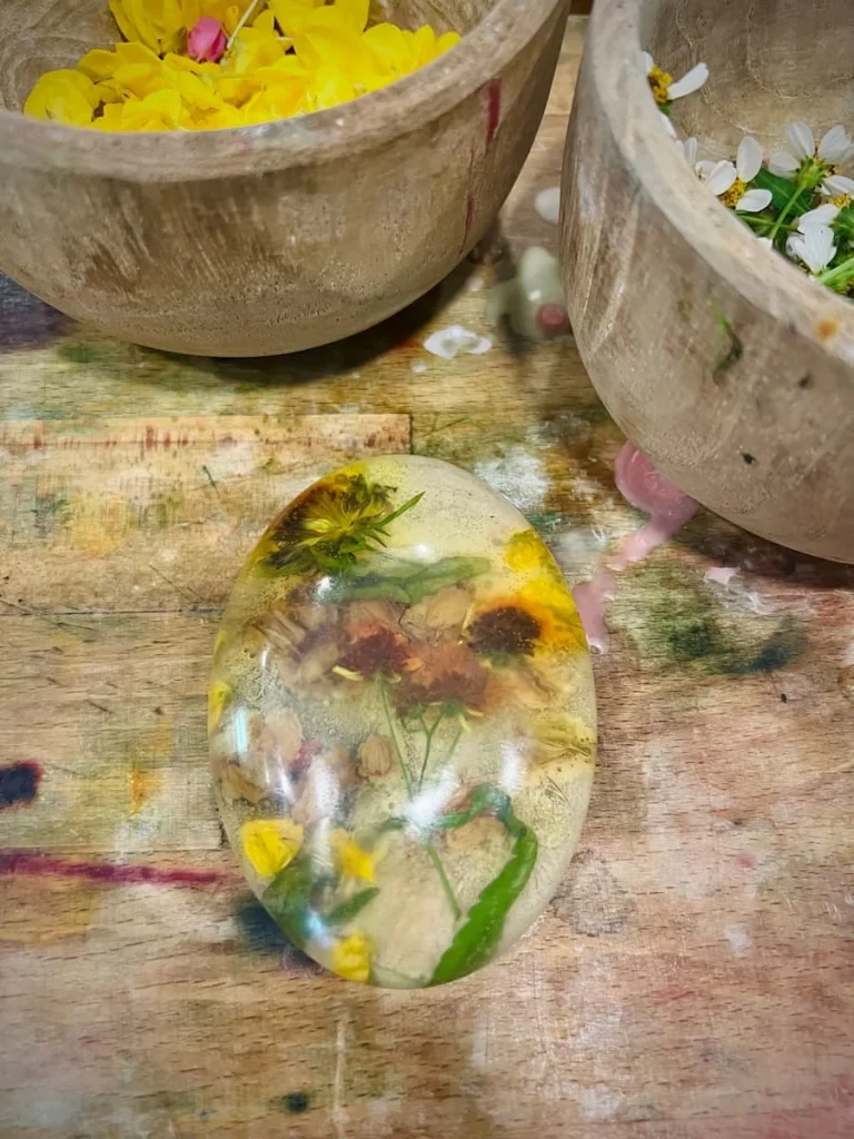 Soap with florals and plants set inside with yellow small flowers and white seeds in the background