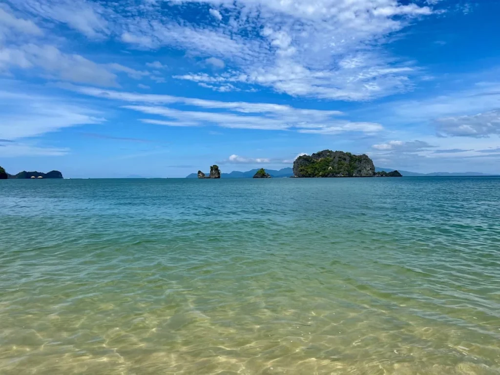 Things to do in Langkawi:  Tanjung Rhu beach with turquoise water and lush green islands in the horizon 