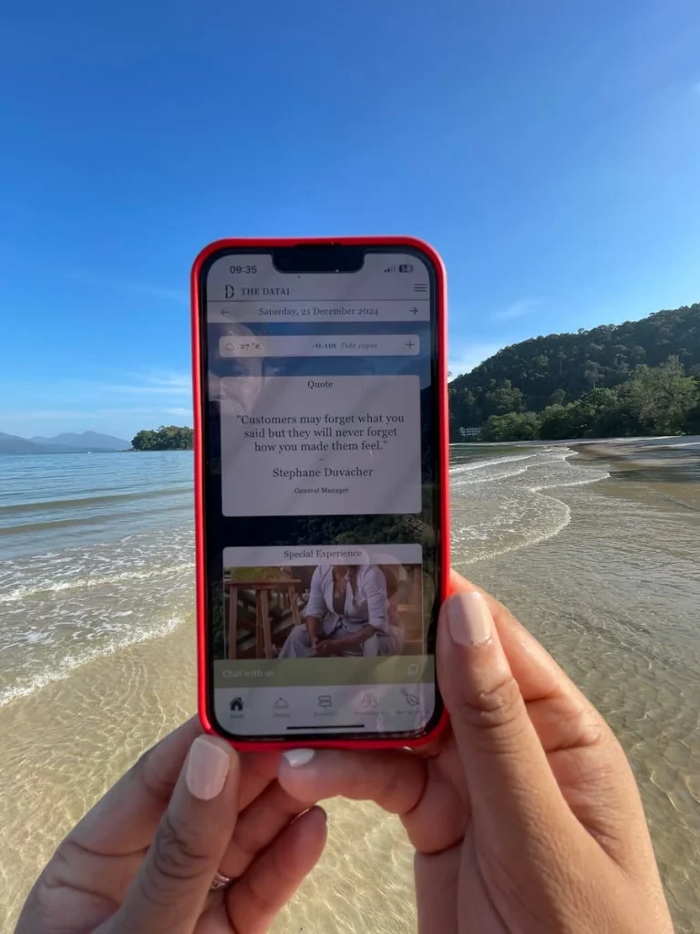 The Datai App with a quote from Stephane Duvacher with the ebach and mountains in the background