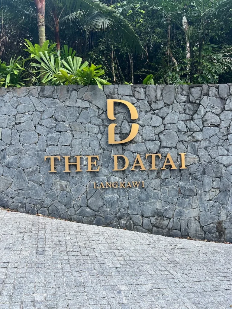 The Datai Langkawi entrance sign in gold with a stoned background