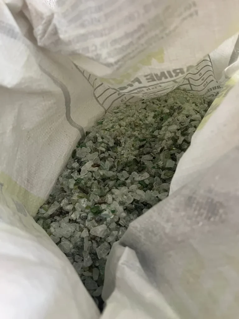 Sustainability at The Datai Langkawi: Black and white Crushed bottle debris in white sacks ready to be used for paths in the resort