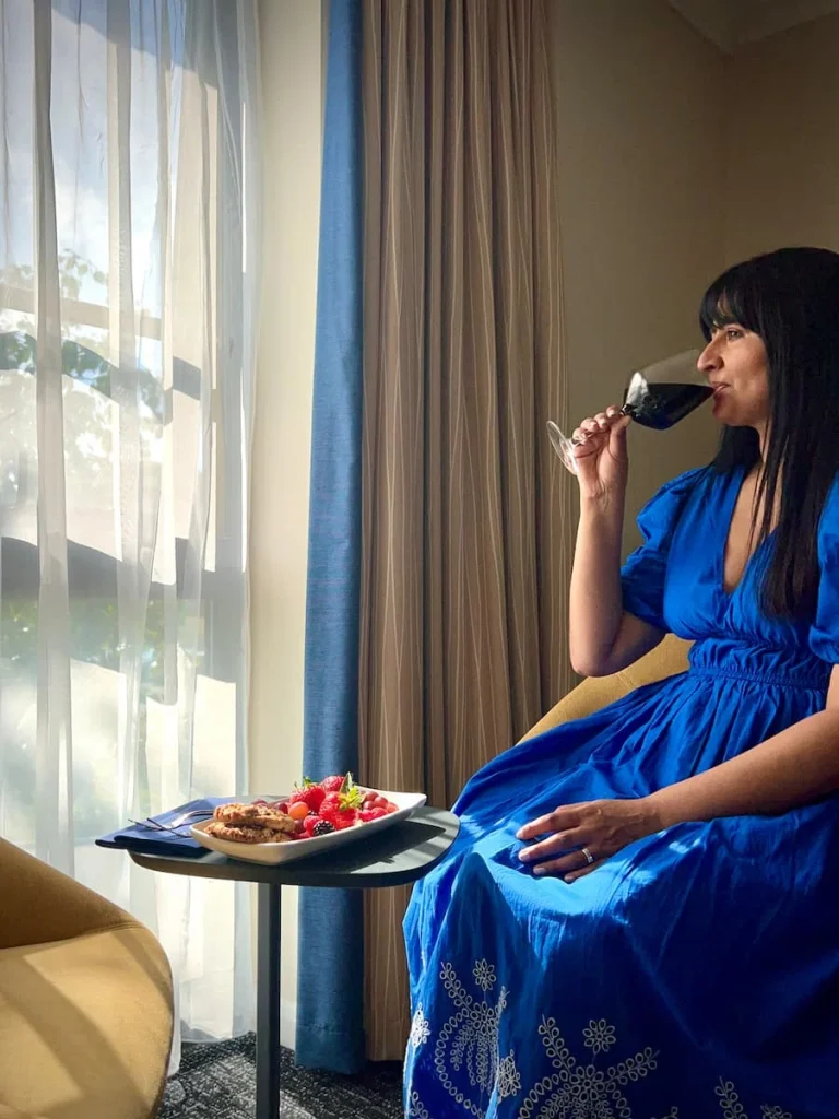 Bejal eating fruit and sipping on red wine in the Chancellor's Suite at Burleigh Court Hotel, Loughborough