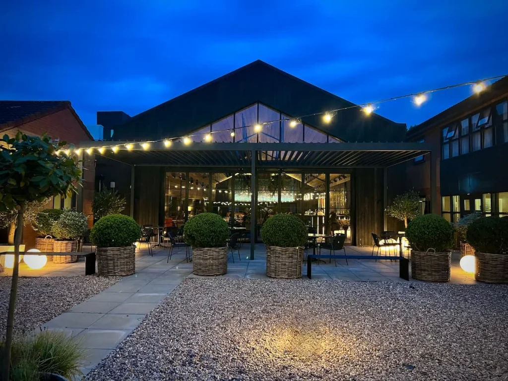 Fifty The Street restaurant at night from the garden terrace with fairy lights on. Burleigh Court Hotel, Loughborough