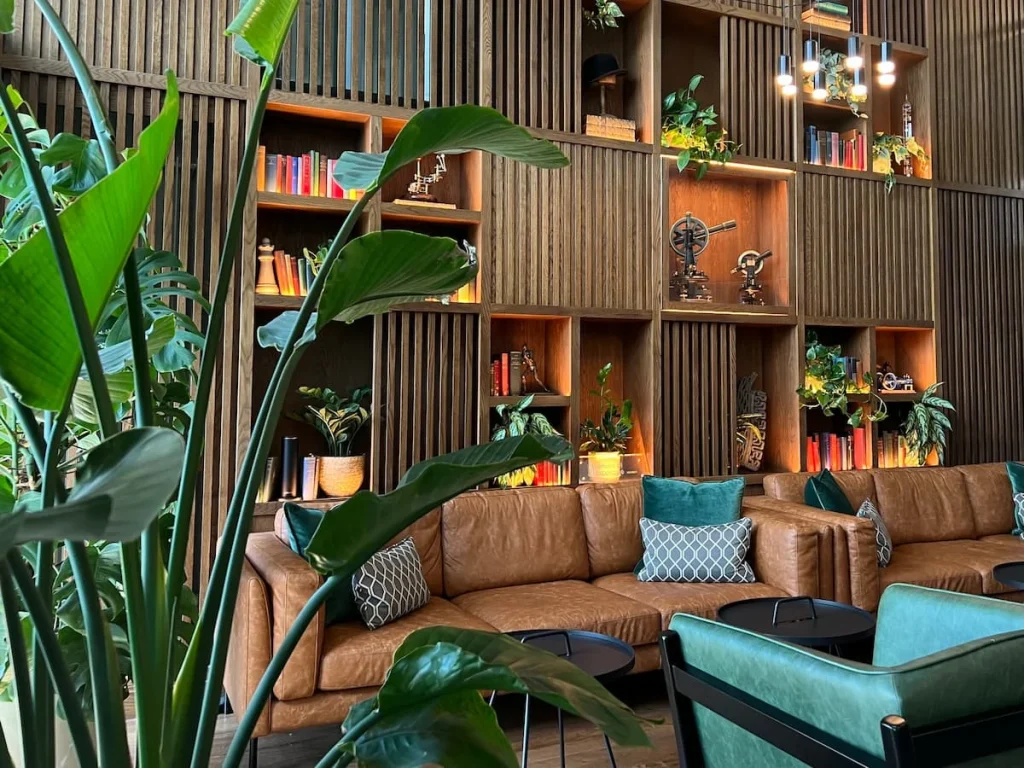 colourful Reception area at Burleigh Court Hotel, Loughborough. Books and artefacts on the dark wood bookcase against the wall