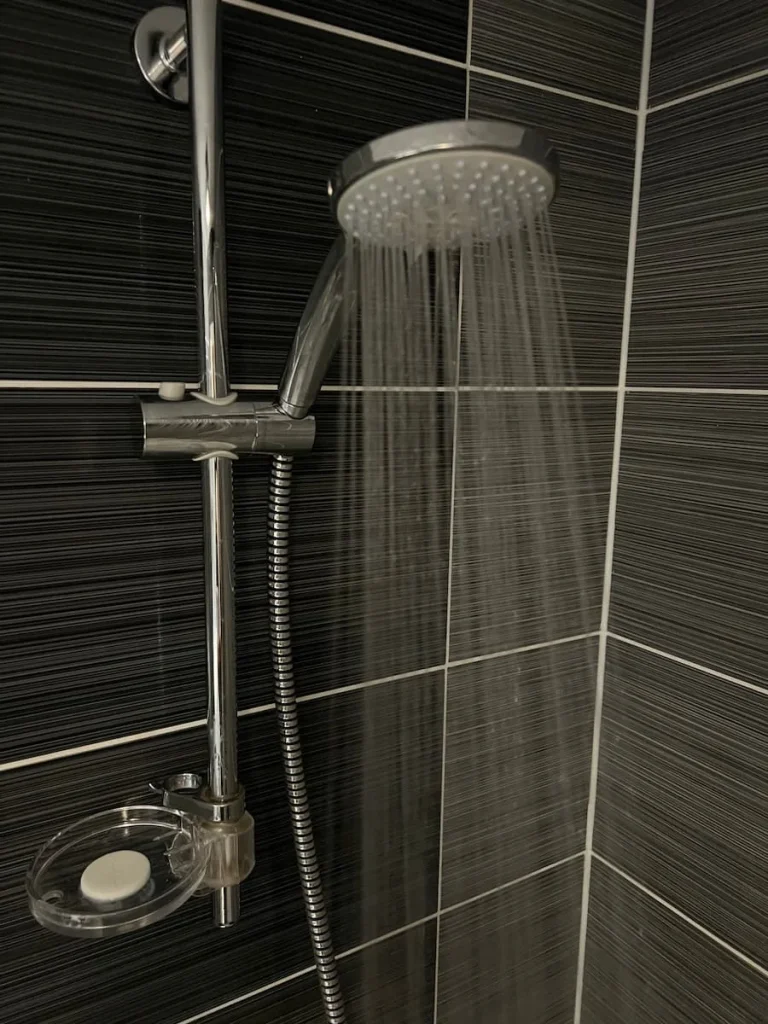Shower head in room with shower on in the Chancellor's Suite, Burleigh Court Hotel, Loughborough