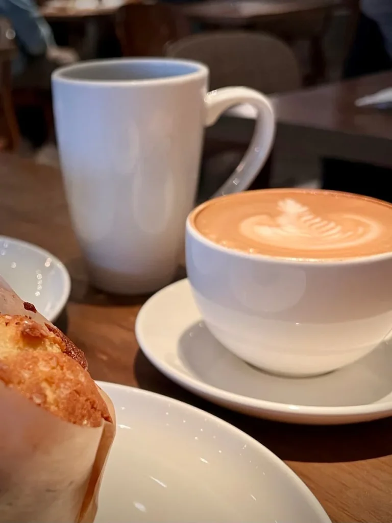 White mug of black coffee and a cappuccino in a white mug at Cupitol coffee, Chicago. One of the coffee shops in Chicago for Vegetarians