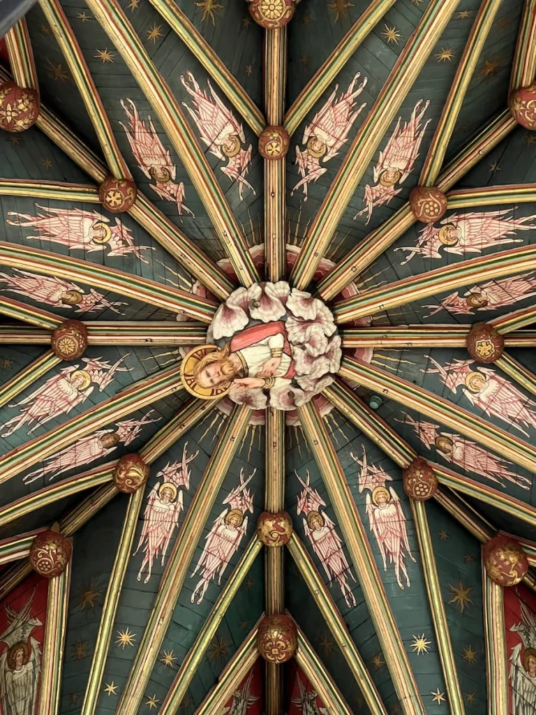 Close up of Octagon ceiling with its intricate details in green and yellow hued paintings in the ceiling of the Octagon Tower, Ely Cathedral, Ely