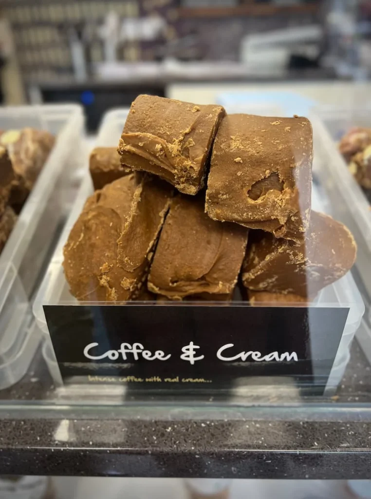 Coffee and cream fudge chunks under the counter with a black sign featuring white lettering reading Coffee & Cream  