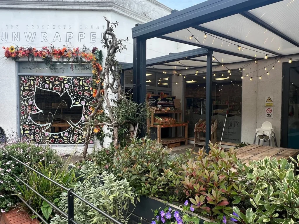 Exterior of Prospects Trust Unwrapped with seating and foliage and dressed for autumn in greens and orange colours