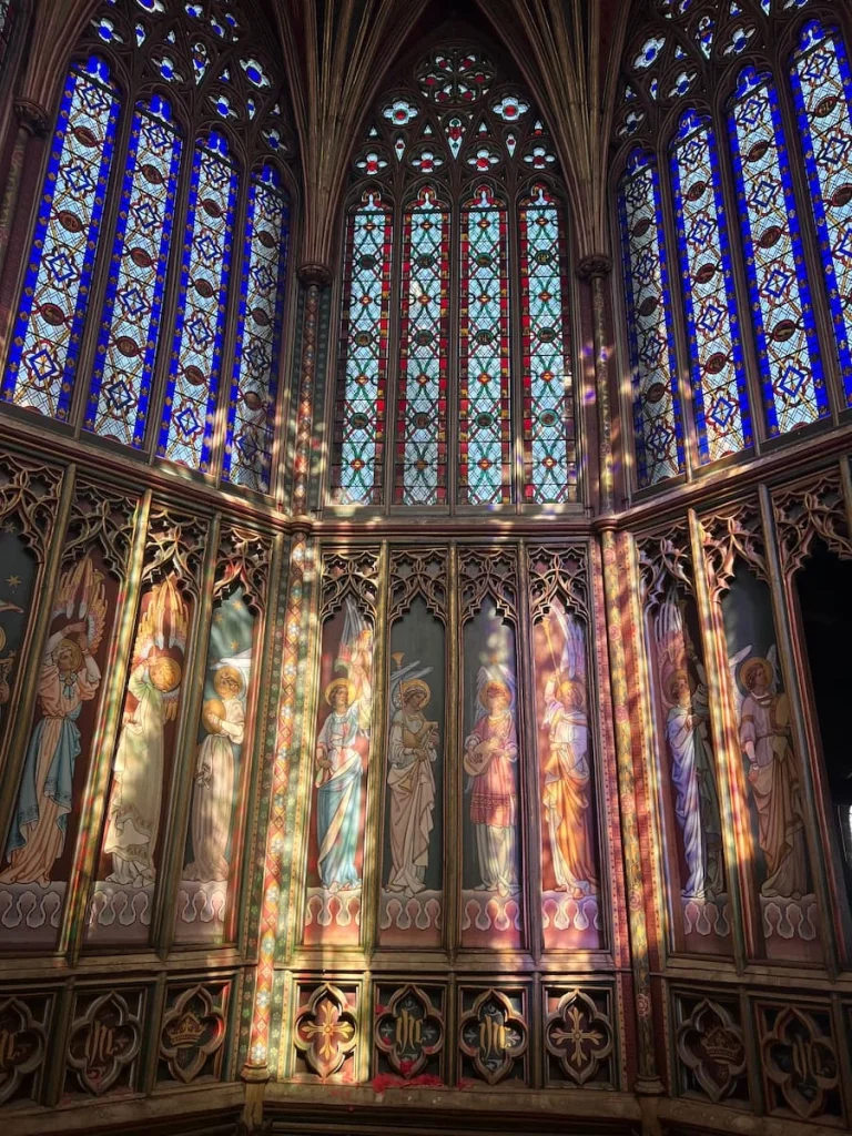 The stained glass panels of the Octagon Tower at Ely Cathedral. The stained glass is pink, blue, red and yellow. Image taken on the Octagon Tower walk.