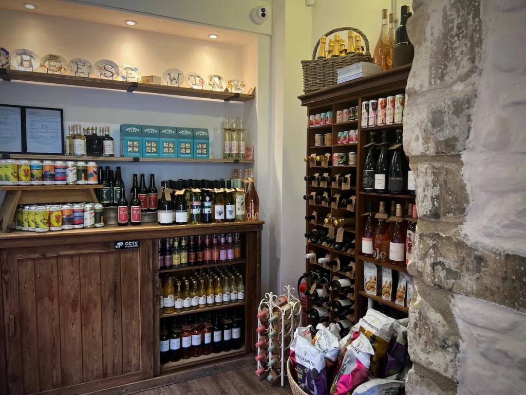 Packaged chutneys, crackers and other offerings at Victoria's Cheese, Ely. The shelving units are wooden brown with a host of dry foods that can be taken away to accompany the cheeses