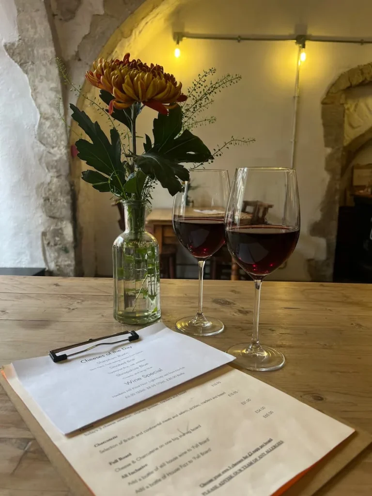 Side view of 2 glasses of red wine and menu at Victoria's Cheese, Ely