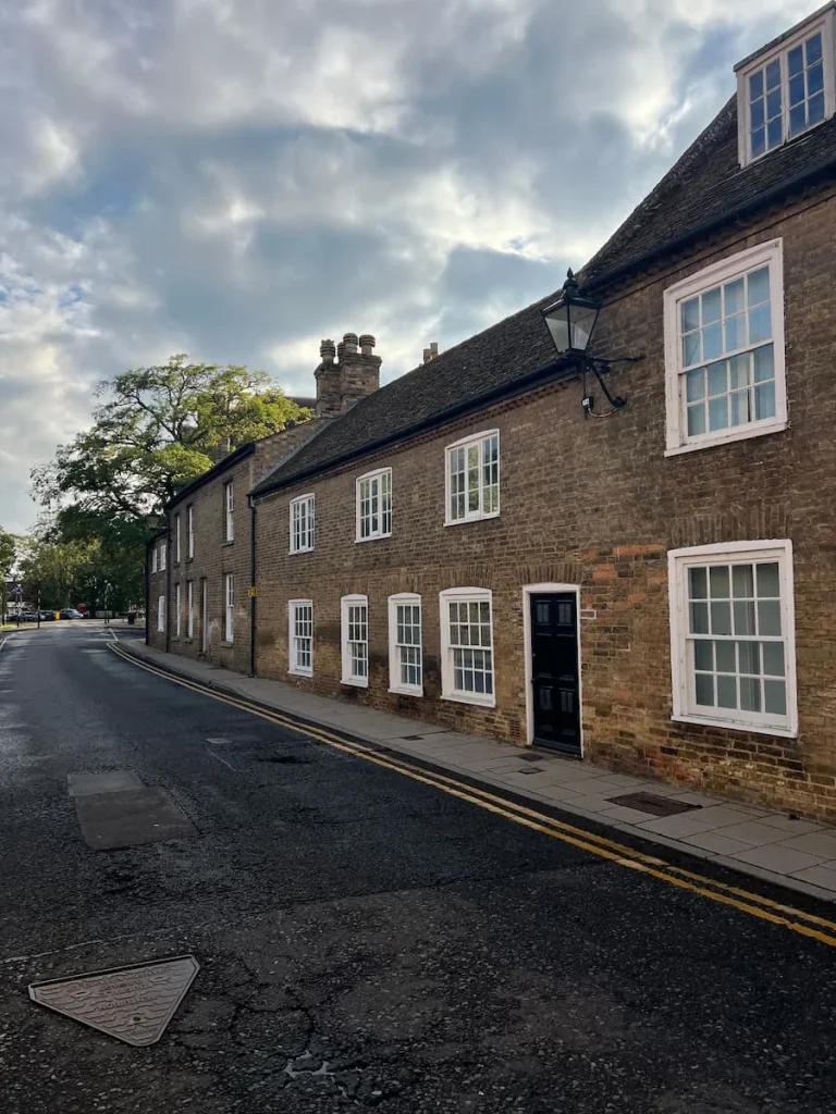 Another row of cottages near Ely Cathedral made from Red Brick with white square windows and small blakc doors