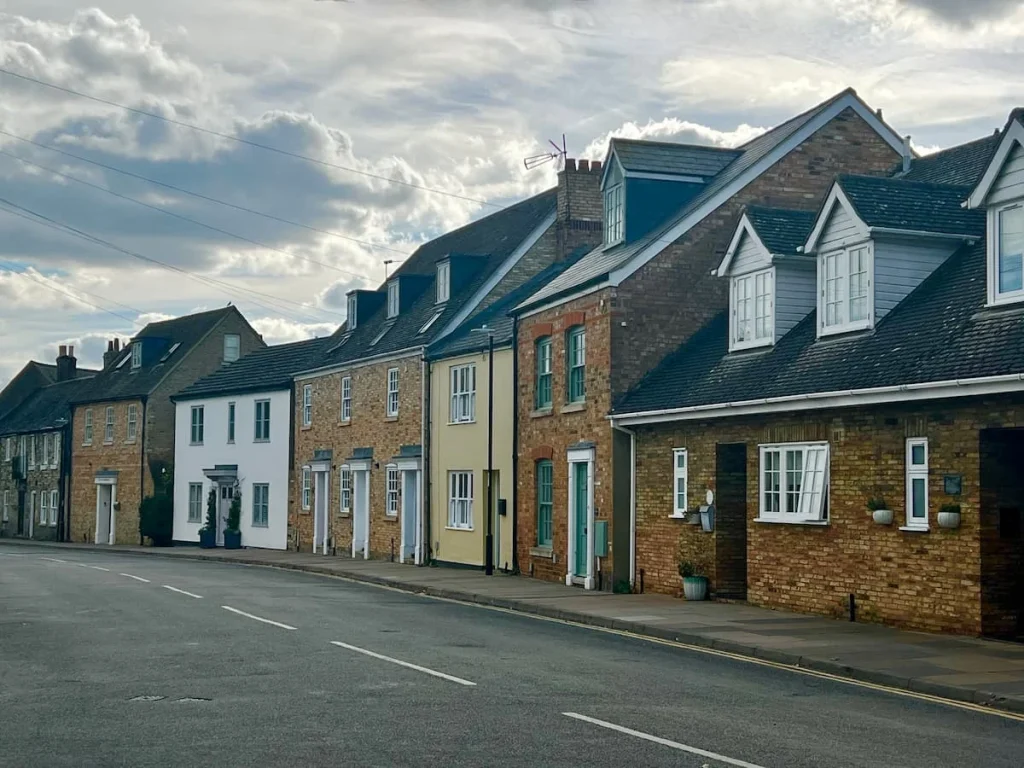A row of small cottages with yellow, white, pink and leach colour facades near the Riversire in Ely