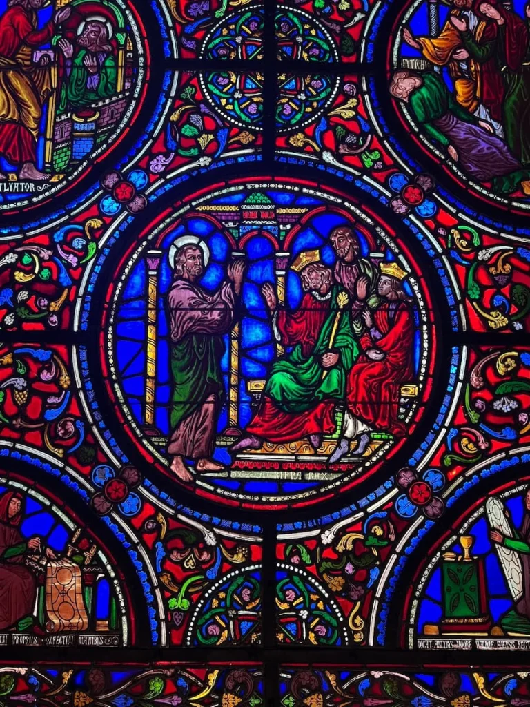 Stained glass windows in Ely Cathedral with blue, red and green colours in a circular design