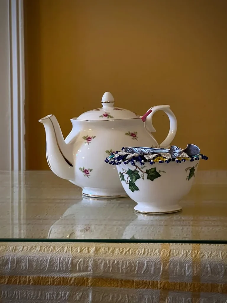 A Teapot with small floral pink design and a sugar bowl with blue patterns at Peacocks Tearooms in Ely