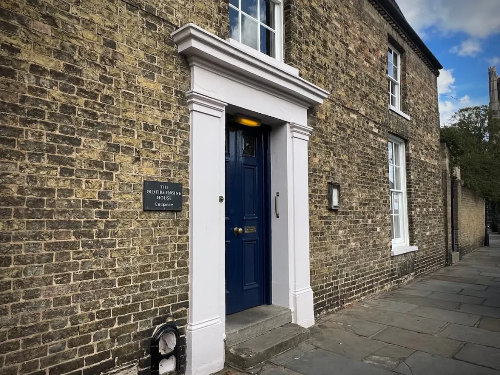 The black front door of the Old Fire Engine House, Ely. The door is of a Regency style and the property is light brick coloured