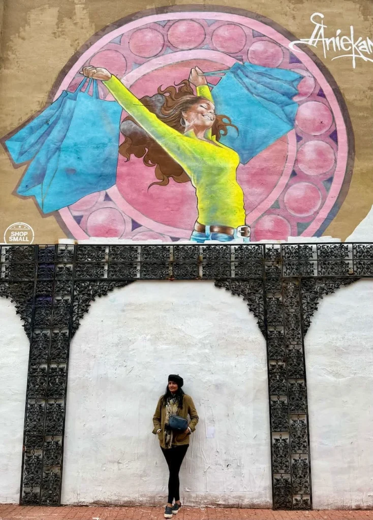 Adams Morgan Street art with Bejal standing underneath one of the white and brown arches in Washington DC