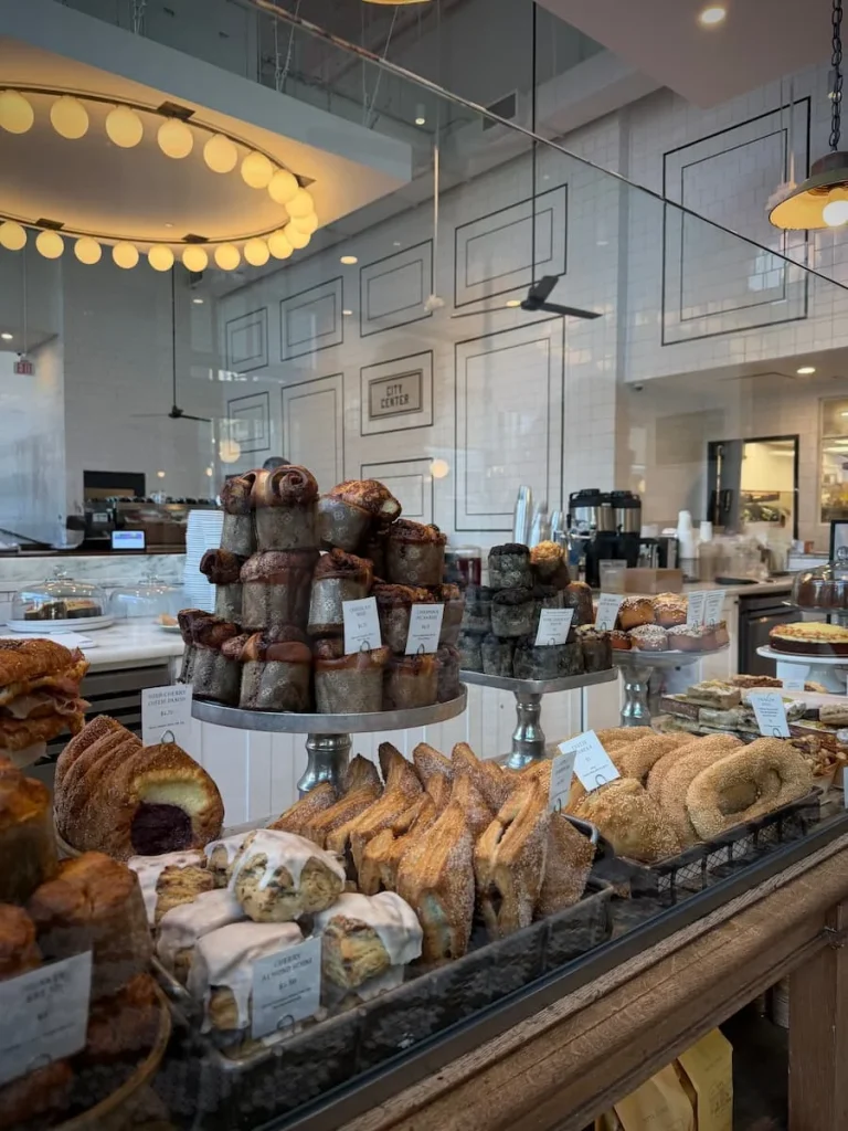 Bakery counter in Tatte, Washington DC. The ciunter is filled with pastries and savoury treats where the servers are taking orders.