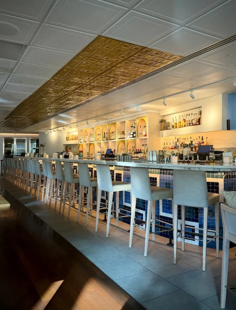 Bar area at Zaytinya Washington DC with white tall stools and spirits agains the back of the bar