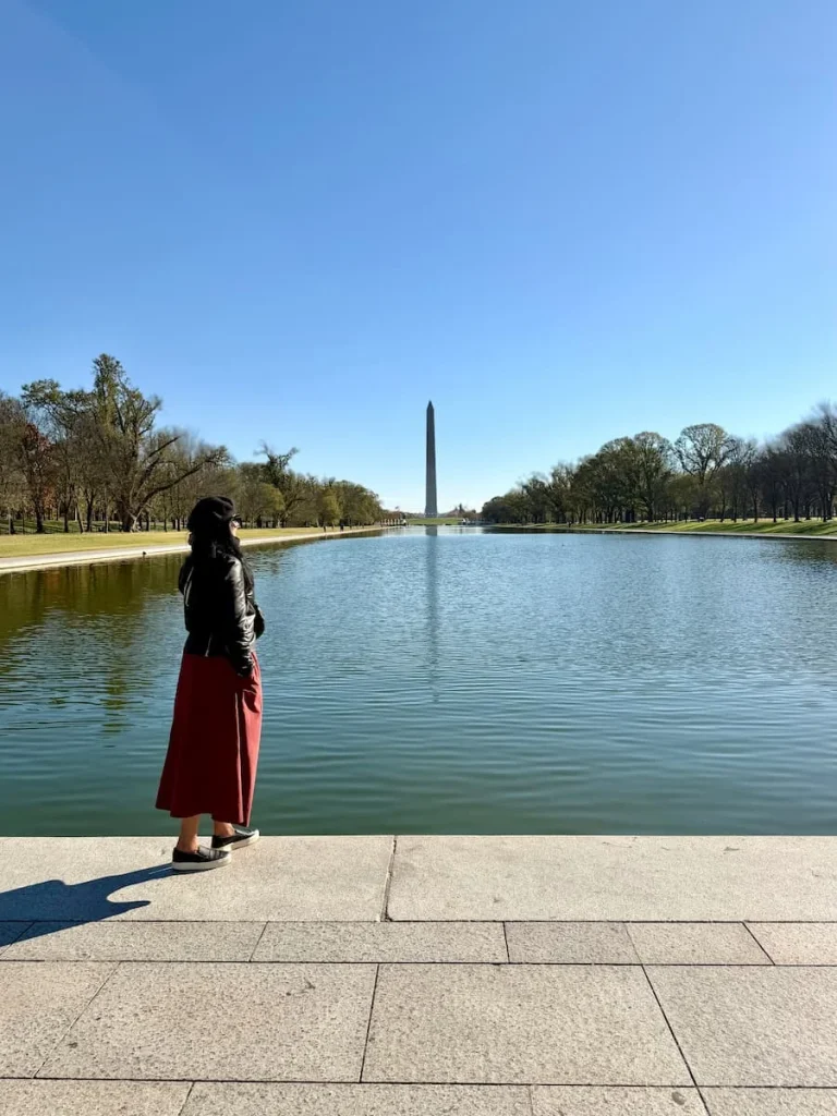 Bejal standing in front of the Reflective Pool with views of the National Monument in Washington DC