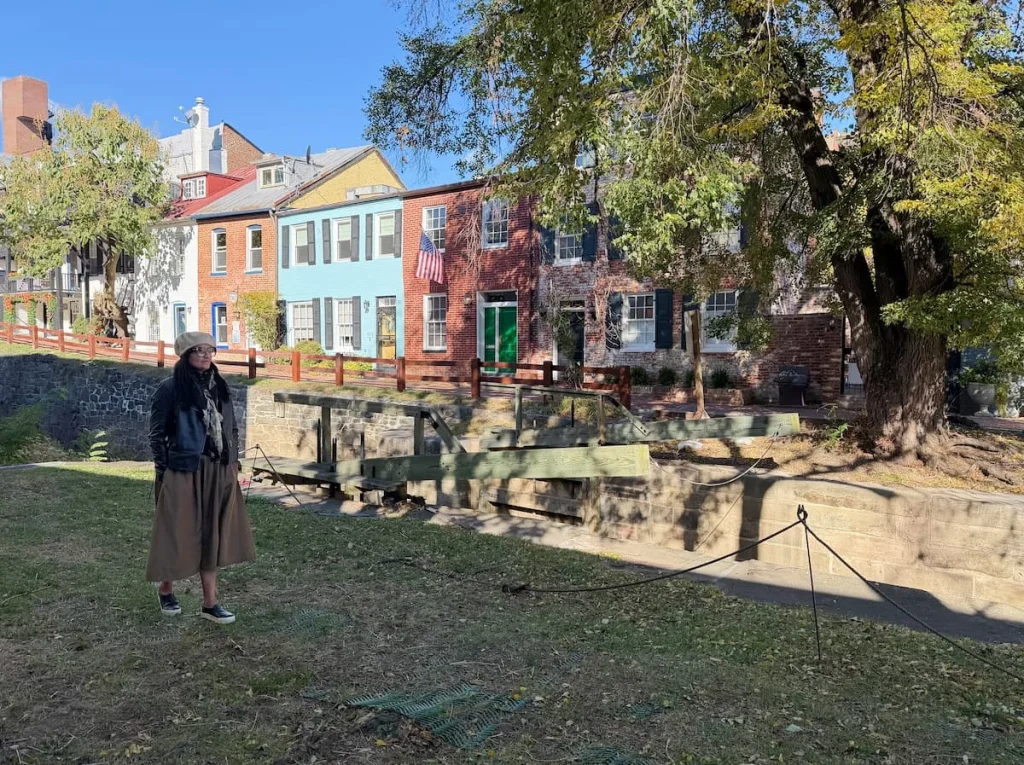 Bejal walking down row of colourful houses next to the C&O Canal, Georgetown, Washington DC.