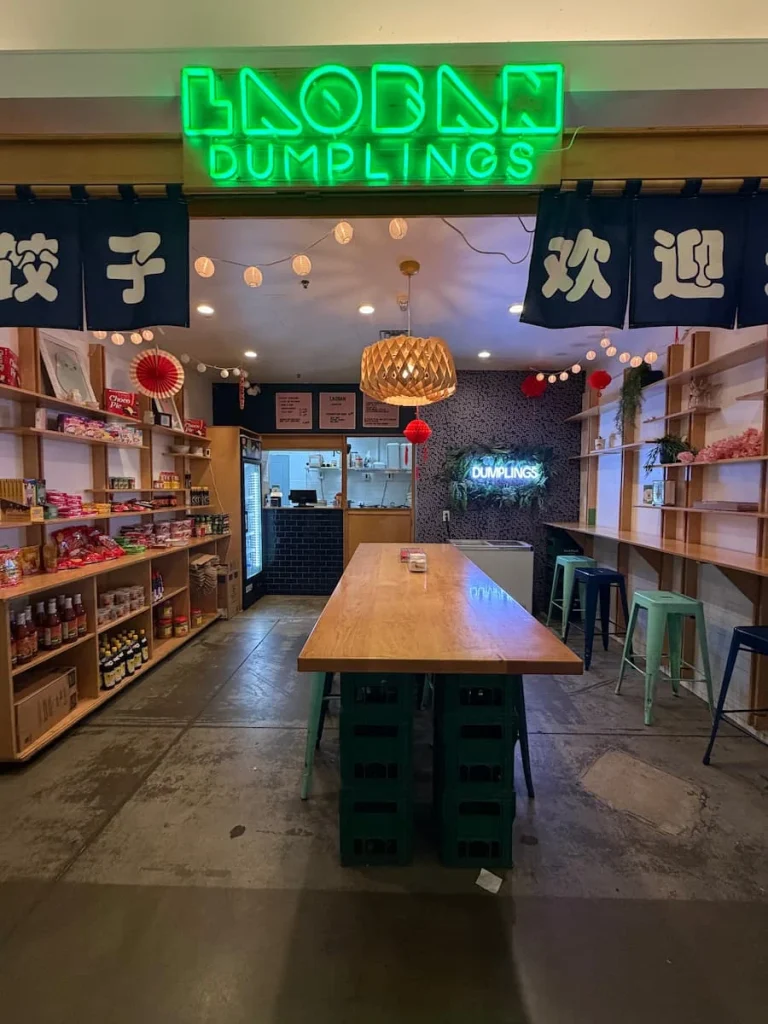 Dumpling stall at Union Market, Washington DC. There is a long table down the middle with side seating