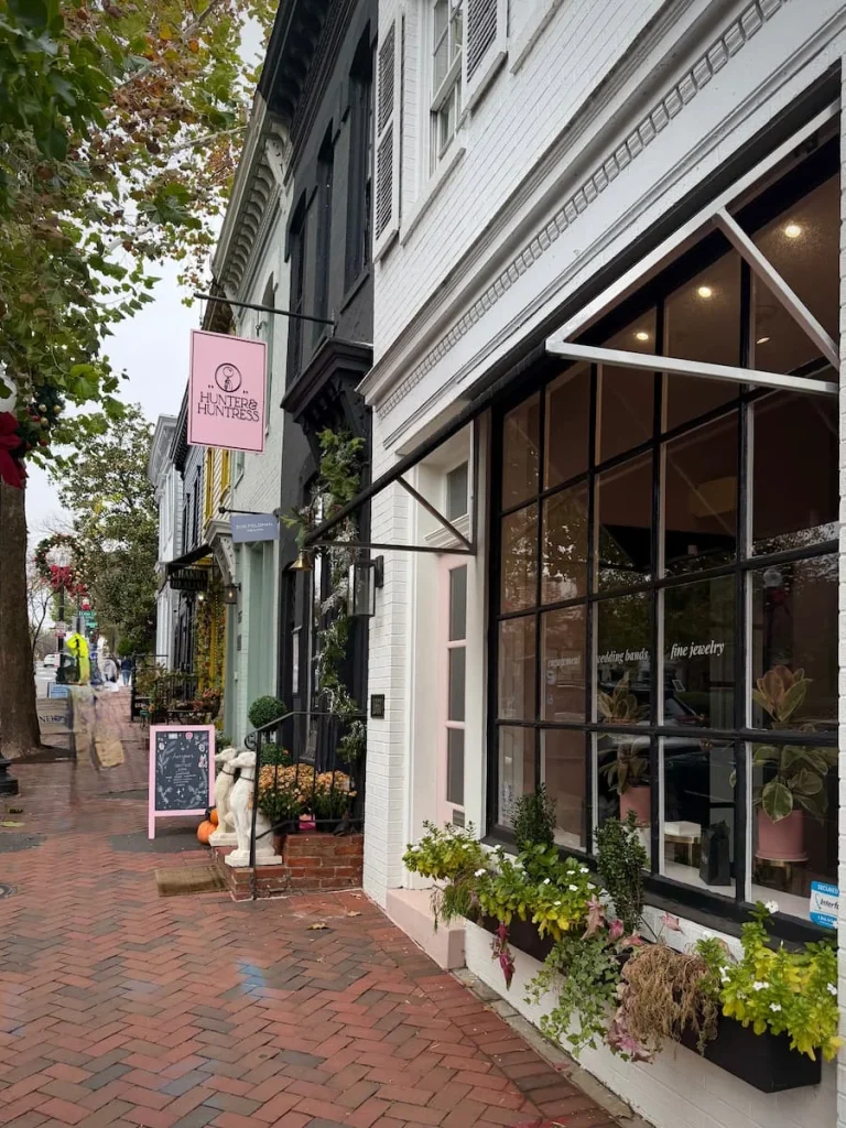 Exterior of Hitched shop in Georgetown Washington DC. A row of shops next to Hitched which has black awning with the store sign on