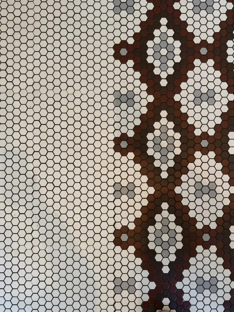 Floor tile design at Tatte Bakery, Washington DC. The dark brown, cream and grey mosaic tiles in a 'Tatte' signature style in the bakery.