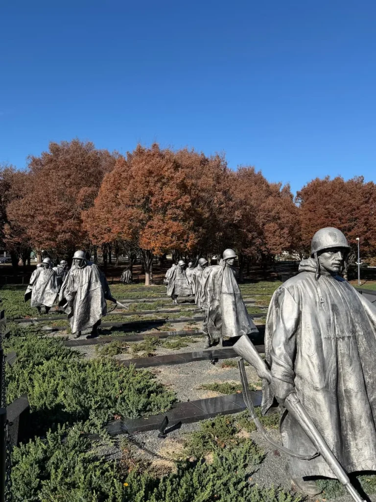 Korean War Veterans Memorial Washington DC, with statues standing in rows with autumnal brown trees in the distance. Downtown has a few sustainable hotels in Washington DC