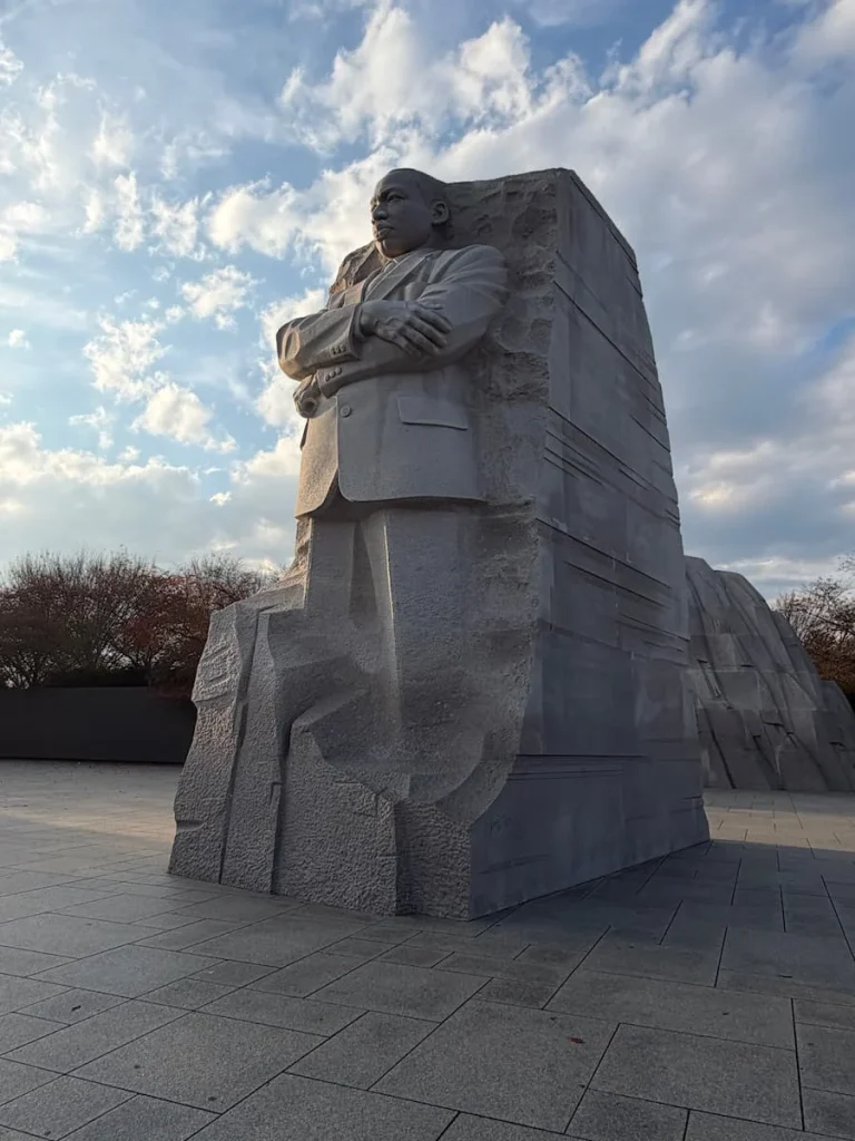 Martin Luther King Junior Statue, Washington DC, with his arms folded wearing a suit, carved from stone