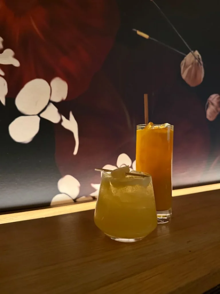 Mezcal cocktails at Planta, Washington DC. They are on a oak wood counter with the Planta signature pink dragon wallpaper in the background.