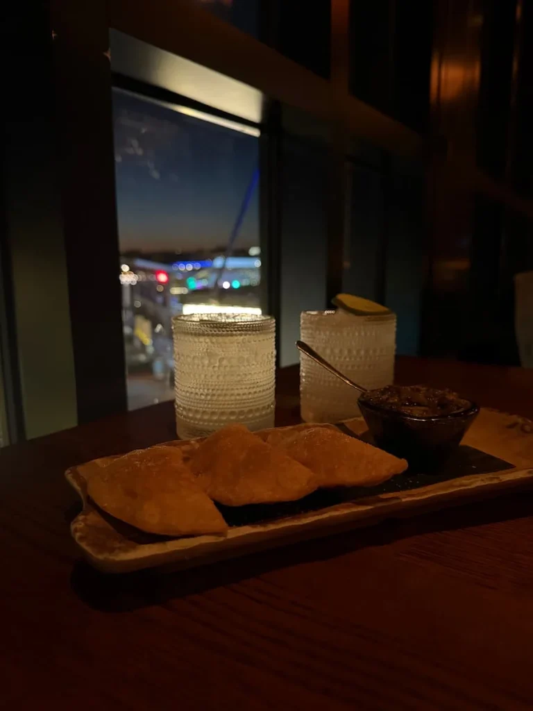 Mezcal cocktails with vegetable empanadas at Mi Vida, Washington DC. District Wharf can be seen in the background