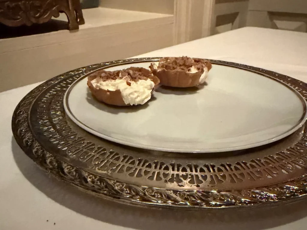 After dinner petit fours at Elizabeths, Washington DC. A white plate with an antique ornate frame with melt in the mouth biscuit petit-fours