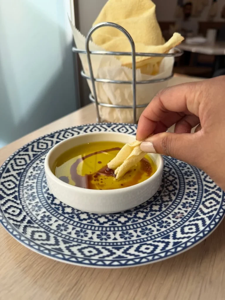 Bread dipped in balsamic vinegar and oil p at Zaytinya Washington DC on a blue and white patterned plate