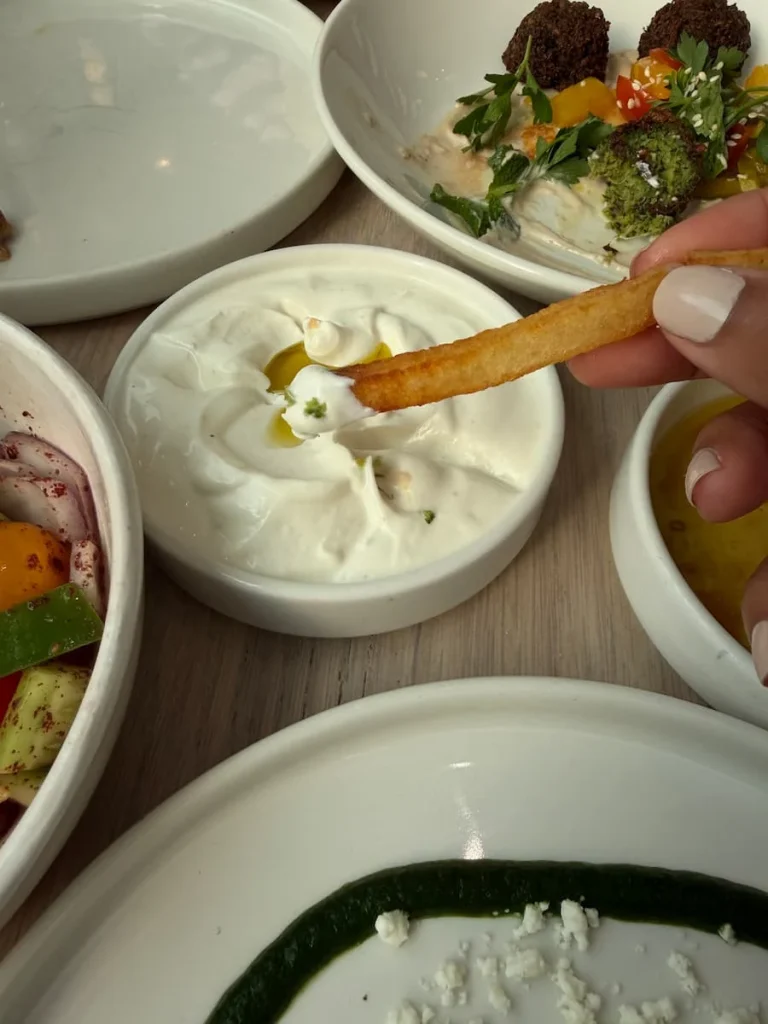Potato fries in a dip at Zaytinya, Washington DC. There are dishes surrounding the main dish