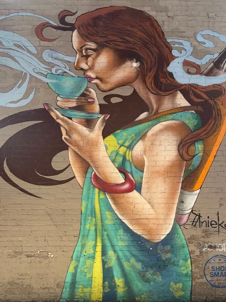 Just Paper & Tea Mural in Georgetown, Washington DC. A girl is sipping on tea in a blue tea cup with front on view