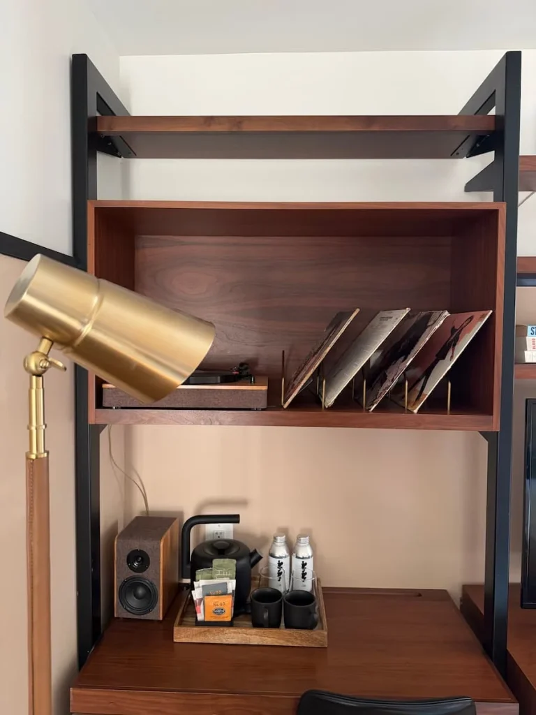 Books and records on shelving in room at Eaton DC, Washington DC. There is a brass shade light in front
