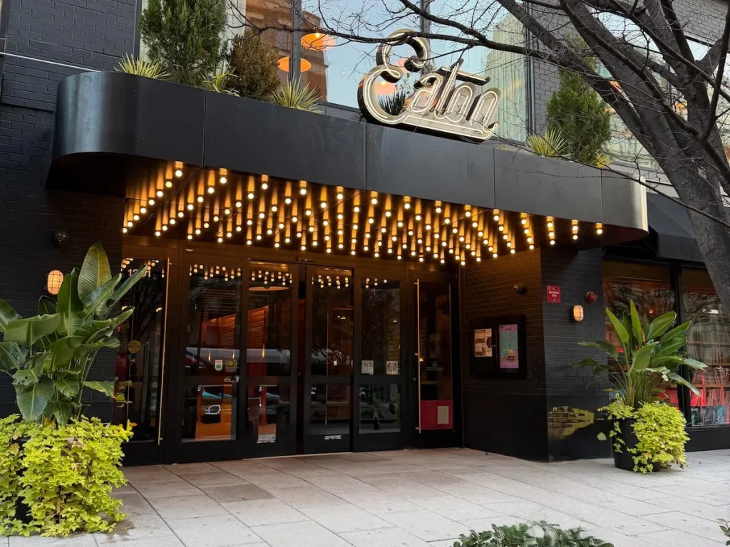 Exterior of Eaton DC Hotel, Washington DC. The entrance has a bunch of light bulbs at the entrance on the black capped ceiling.