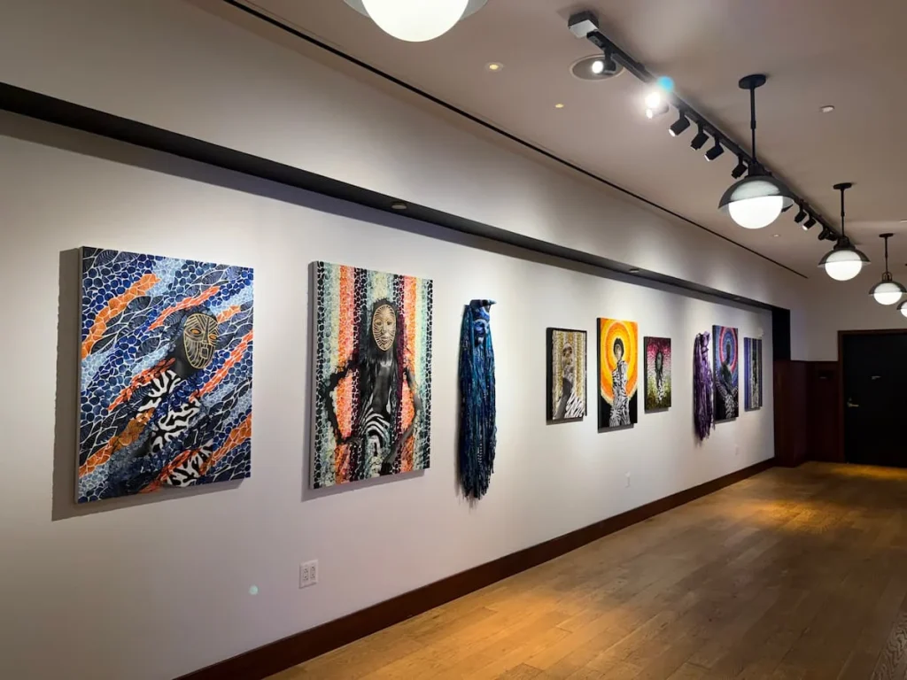 Gallery wall with African America art at Eaton DC, Washington DC. There are a number of colourful artworks against a white washed wall