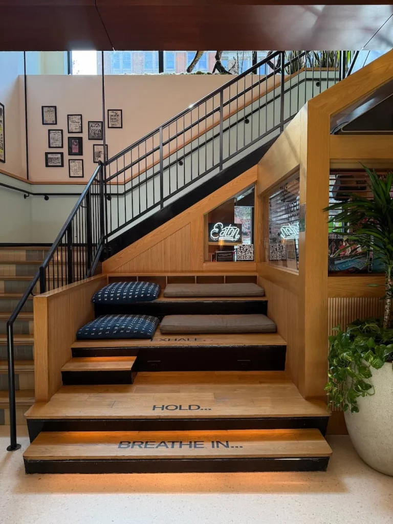 Ground floor stairs at Eaton DC, Washington DC. There are cushiios on the stairs to serve as seating for guests