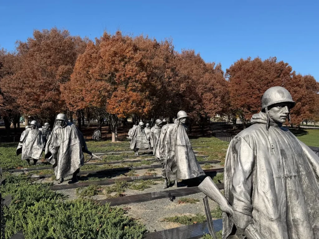 Korean War Veterans Memorial Washington DC, with statues standing in rows with autumnal brown trees in the distance
